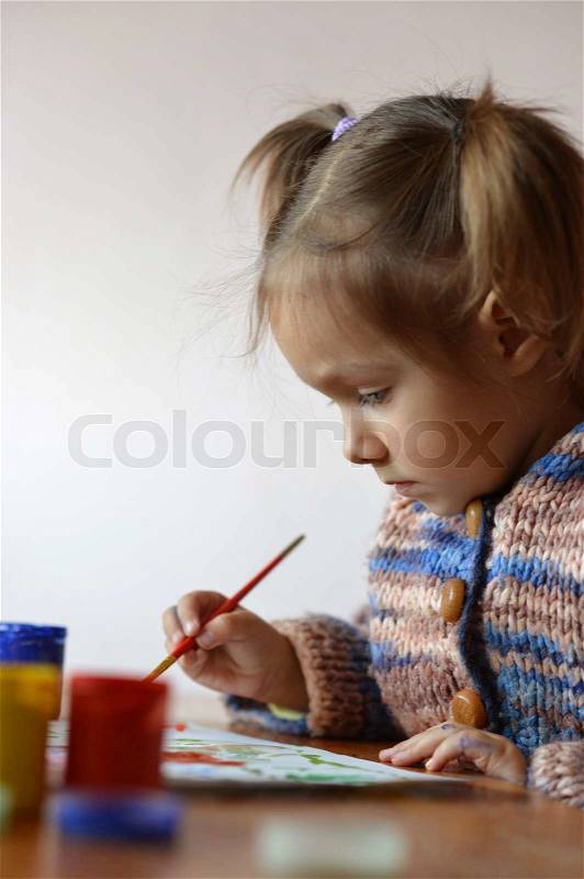 Portrait of a cute baby draws, stock photo