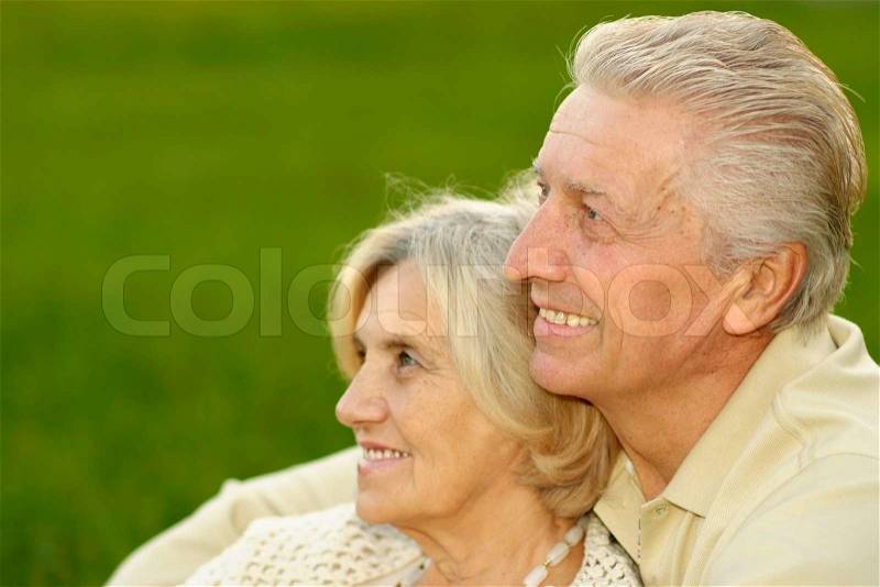 Happy cute couple sitting at summer park, stock photo