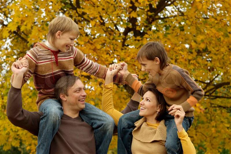 Portrait of a beautiful happy family playing in autumn park, stock photo