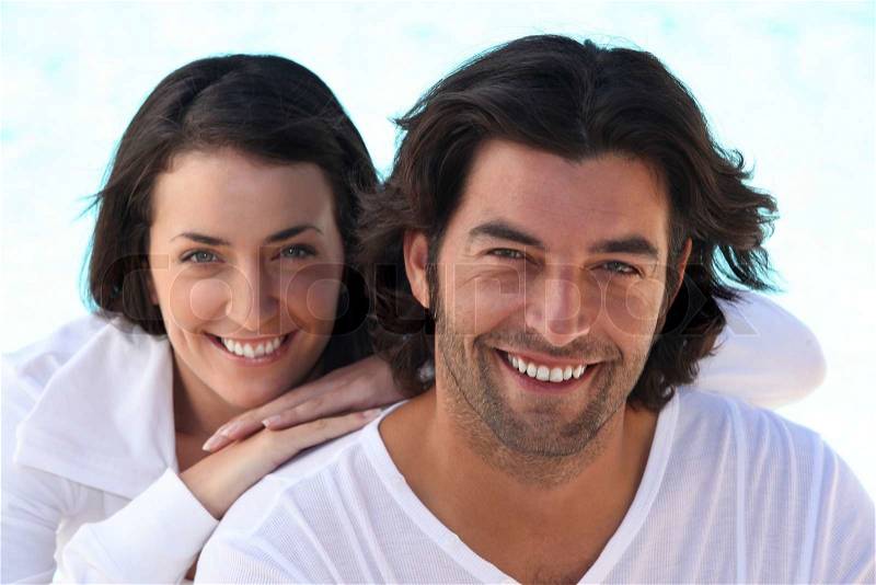 Head and shoulders shot of a well matched couple in white, stock photo