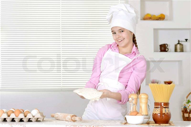 Cute girl baking cake in the kitchen at home, stock photo