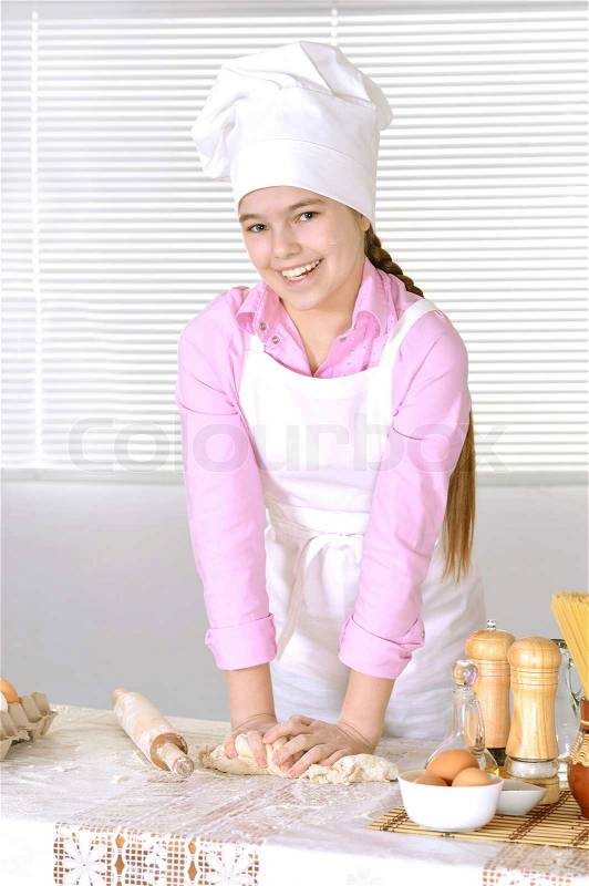 Cute girl baking cake in the kitchen at home, stock photo