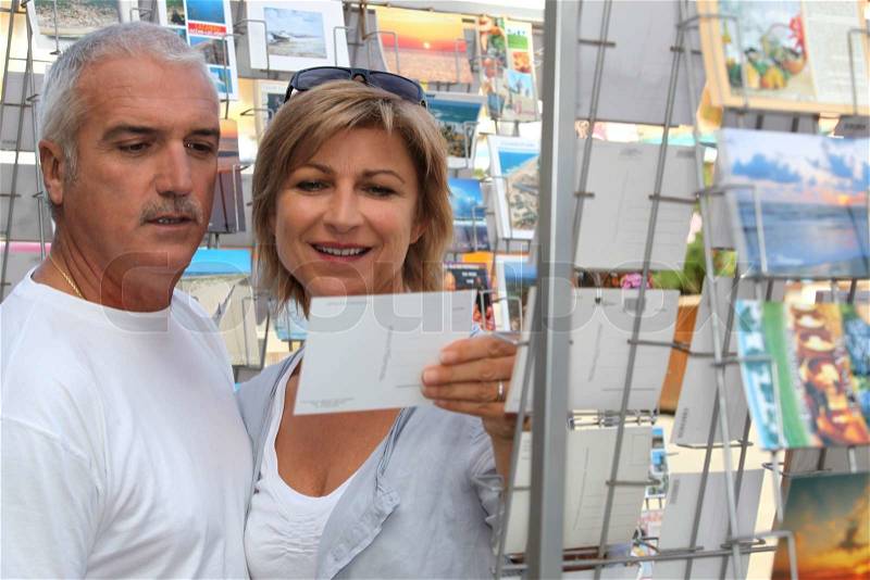 Couple choosing a postcard, stock photo