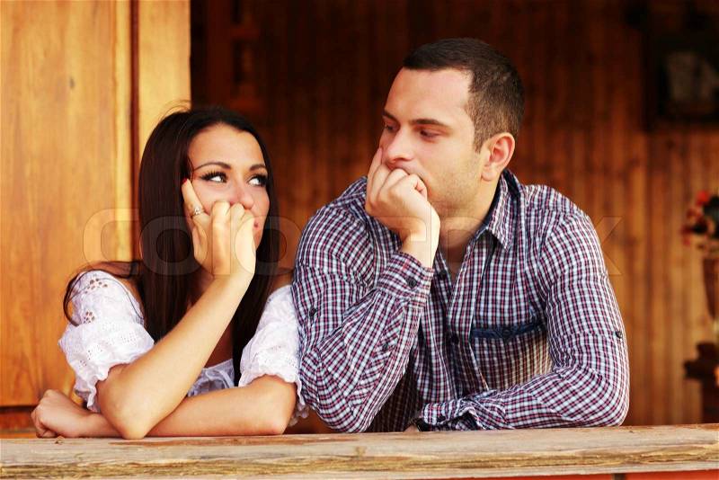 Young thinking couple looking at each other, stock photo