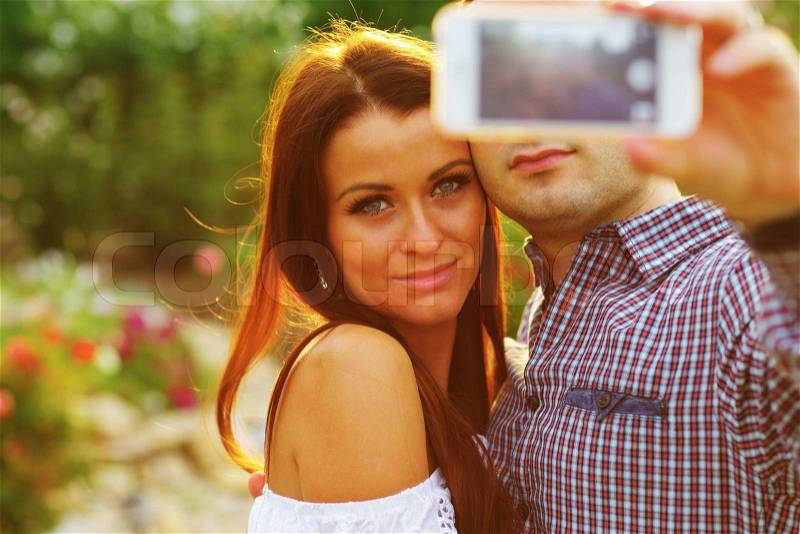 Couple taking self-portrait photos with mobile smart phone, stock photo