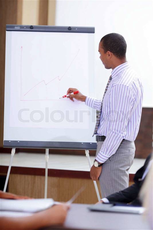 Young african-american man presenting project to his colleagues, stock photo