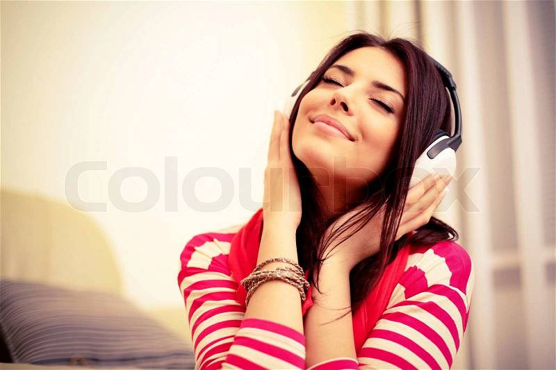Young beautiful woman in bright outfit enjoying the music at home, stock photo