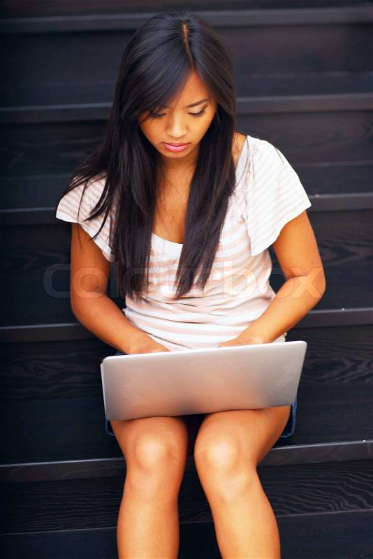 Young beautiful asian woman using laptop on stairs, stock photo