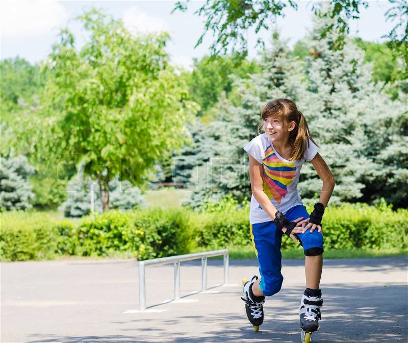 Teenage girl limbering up before going roller skating stretching her muscles and bending while laughing and smiling in anticipation, stock photo