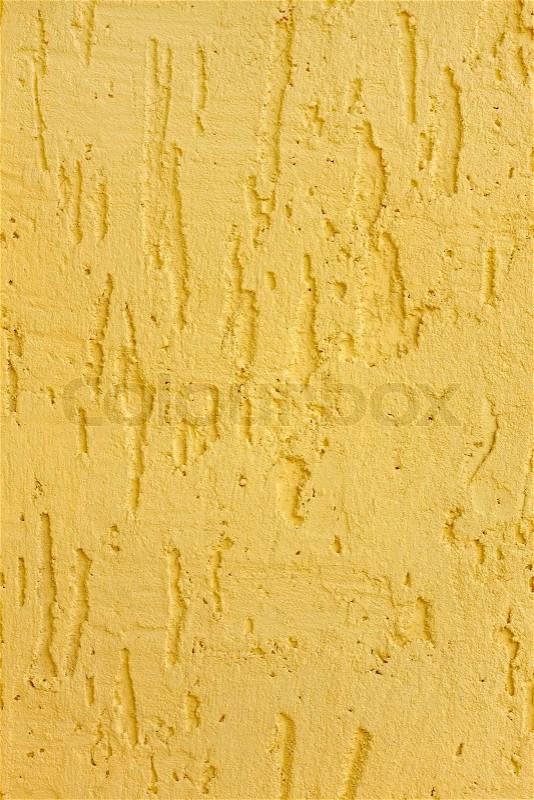 Fragment of a relief plaster walls yellow color closeup as a texture, stock photo