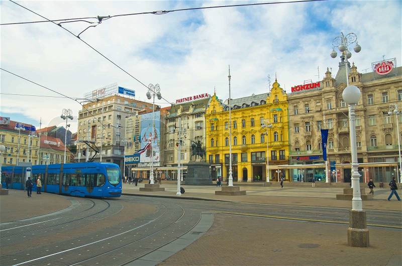 ZAGREB, CROATIA - MARCH 18: People walk along city street with old houses and travel by tram in Zagreb, Croatia on March 18, 2012. Zagreb Tram run by the Zagrebacki elektricni tramvaj ZET, stock photo