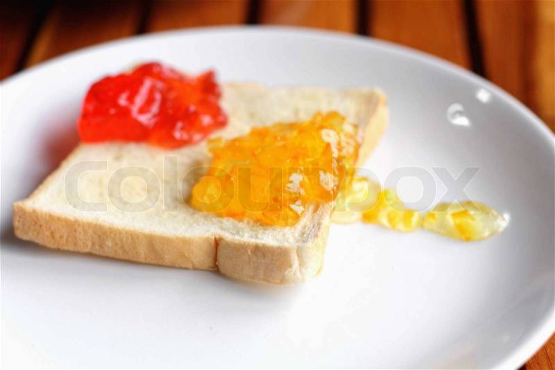 Bread and jam on a wooden table, stock photo
