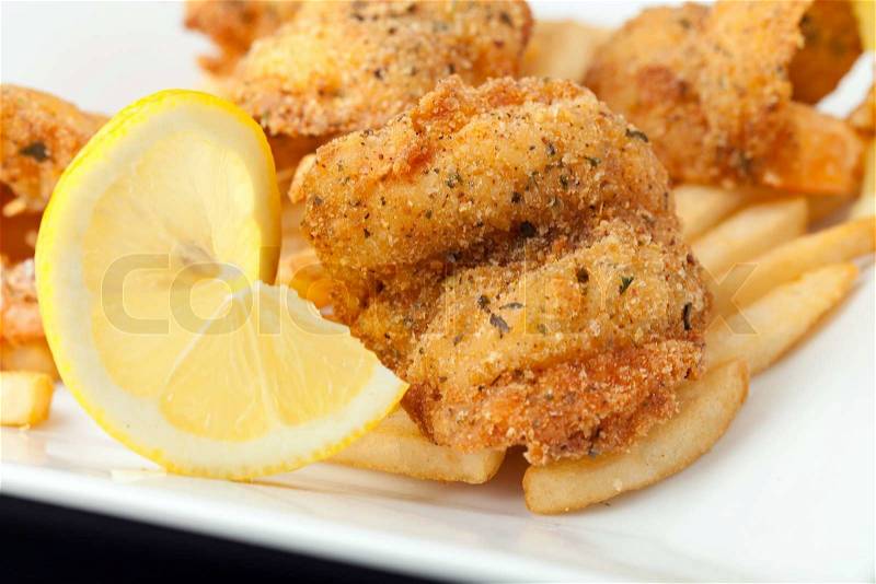 Fried shrimp and french fries plate garnished with lemon, stock photo