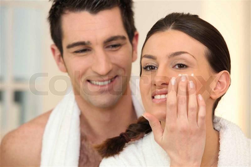 Woman applying under eye cream, stock photo