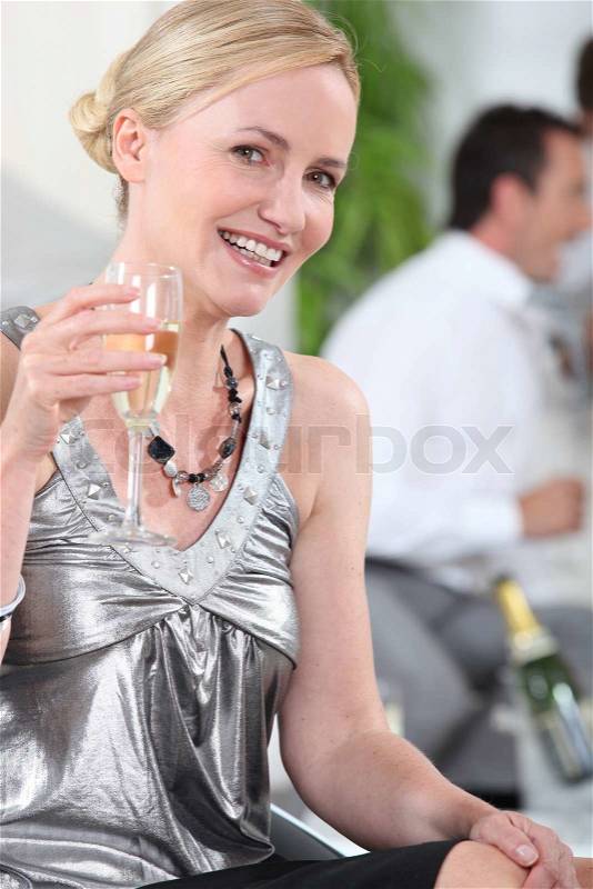 Woman drinking champagne in silver top, stock photo