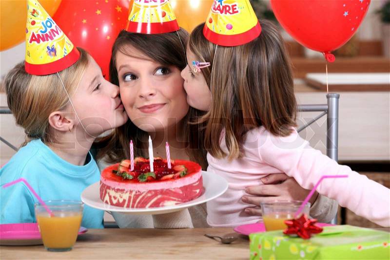 Sisters kissing mom at birthday\'s party, stock photo