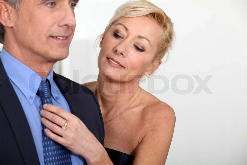 Woman fixing her husband\'s tie, stock photo