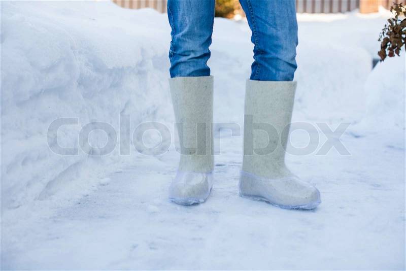 Close-up of warm boots for men\'s feet on the white snow, stock photo