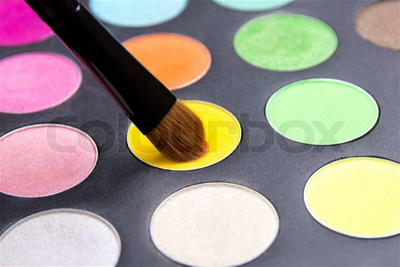 Close up of Make-up brush and colorful eyeshadow palette over black background, stock photo