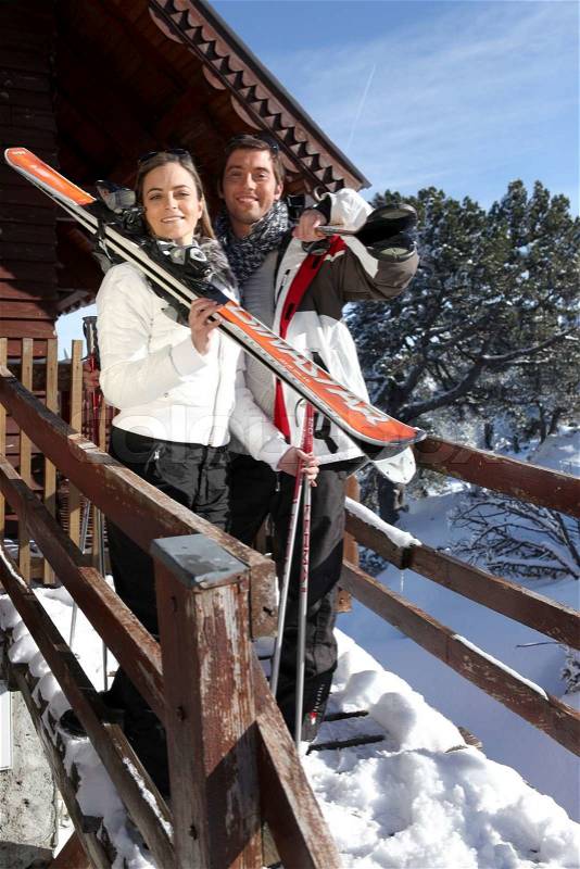 Couple outside a ski lodge, stock photo