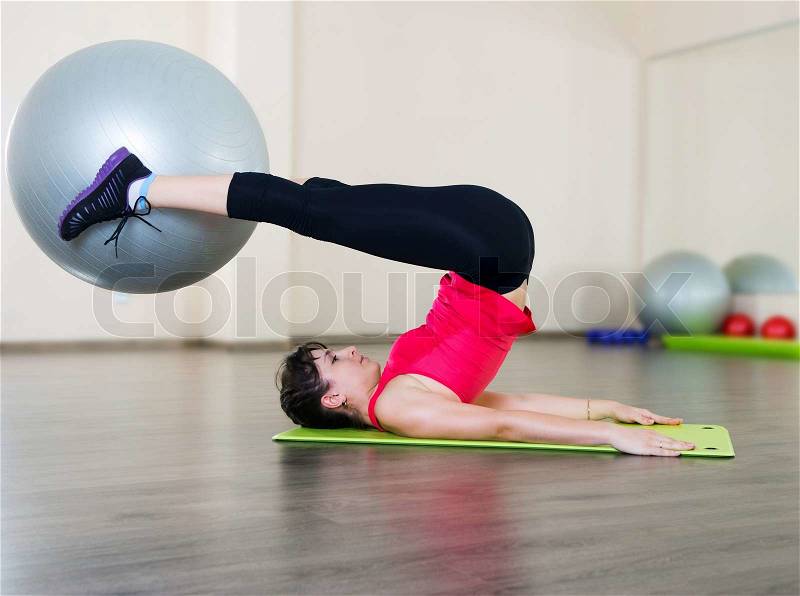 Pretty young woman fitness workout in gym with fitball, stock photo