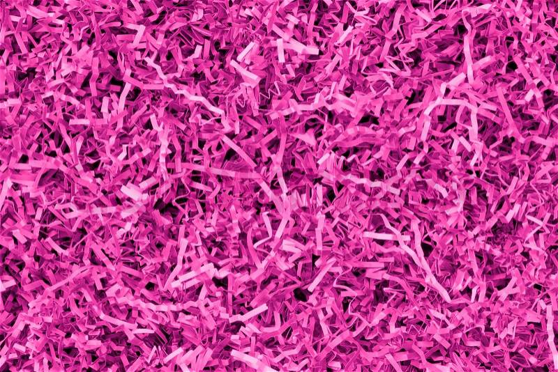 Close-up of pink and magenta shredded paper packaging material background, stock photo