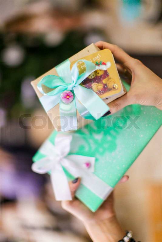 Close-up a Christmas gift in the hands of young woman at New Year\'s Eve, stock photo