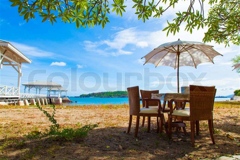 Chairs and table under umbrella Near the sea At the bright air. On of Weekend, stock photo