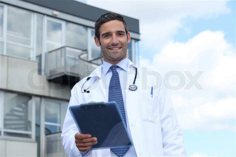 Doctor standing outside hospital, stock photo