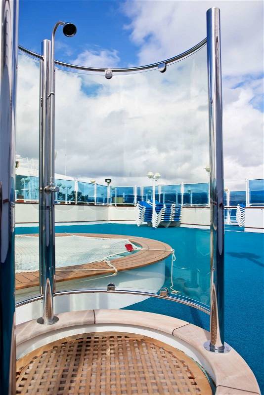 On sundeck of the cruise ship: deck chairs, shower, and pool, stock photo