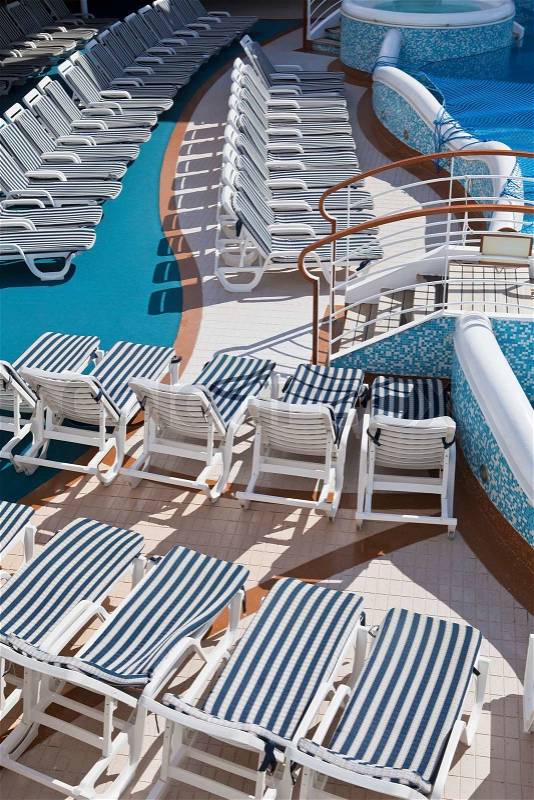 Rows of deck chairs on sundeck of the cruise ship by the pool, stock photo