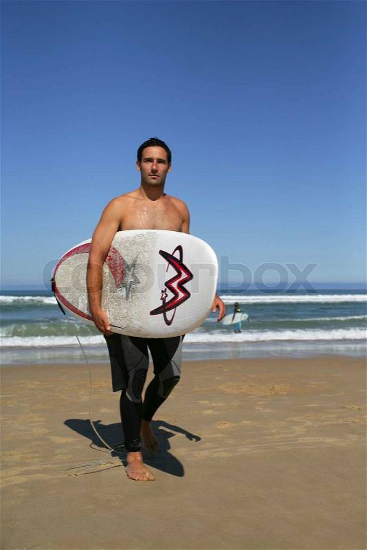 Beautiful young man surfing, stock photo