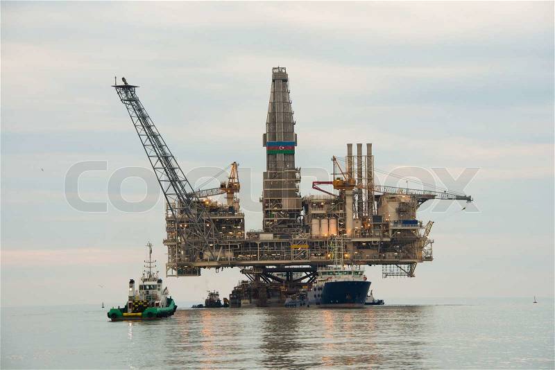 Oil rig being tugged in the sea, stock photo