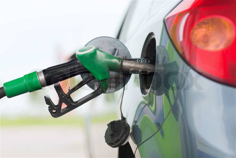 Transportation and ownership concept - pumping gasoline fuel in car at gas station, stock photo