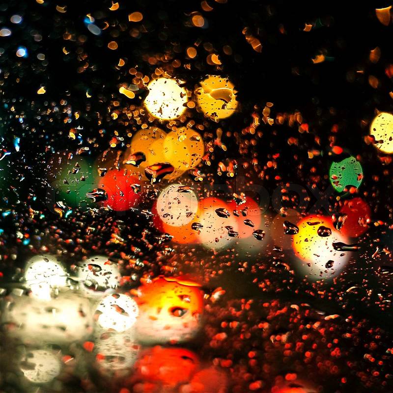 Rain drops on car glass in rainy night, stock photo