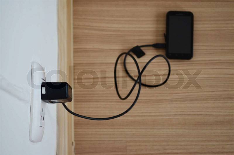 Mobile phone and charger, stock photo