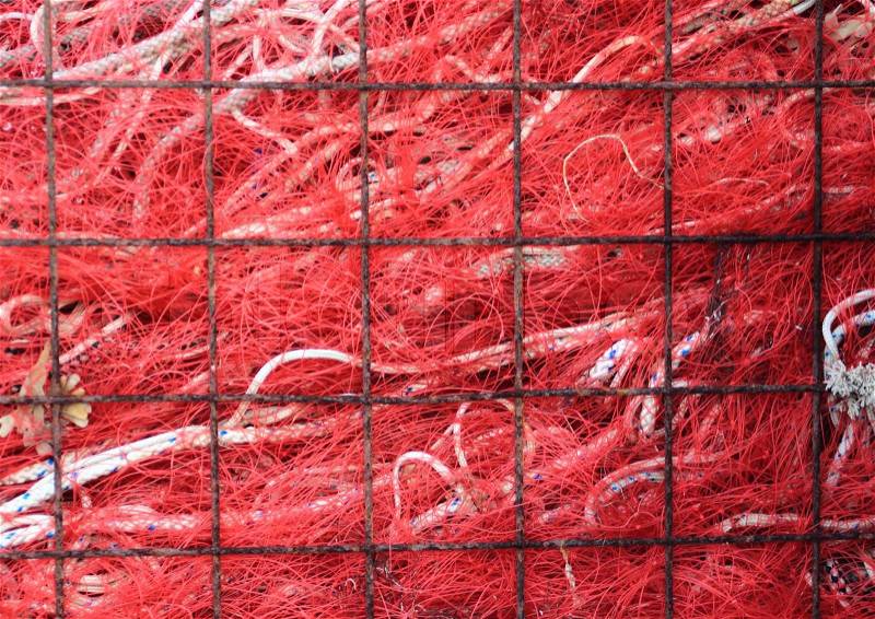 Red industry fishing net in rusty metal grid, stock photo