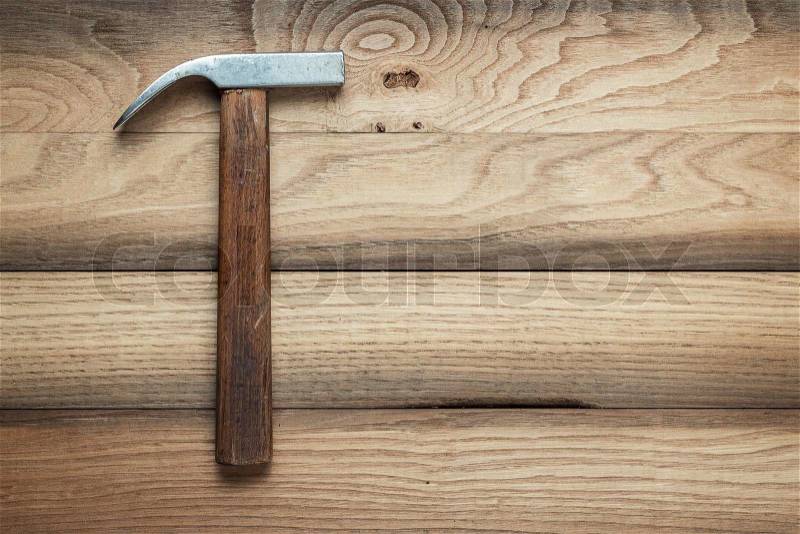 Claw hammer on the brown wooden background, stock photo