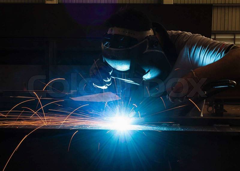 Man with welding helmet welding steel , stock photo