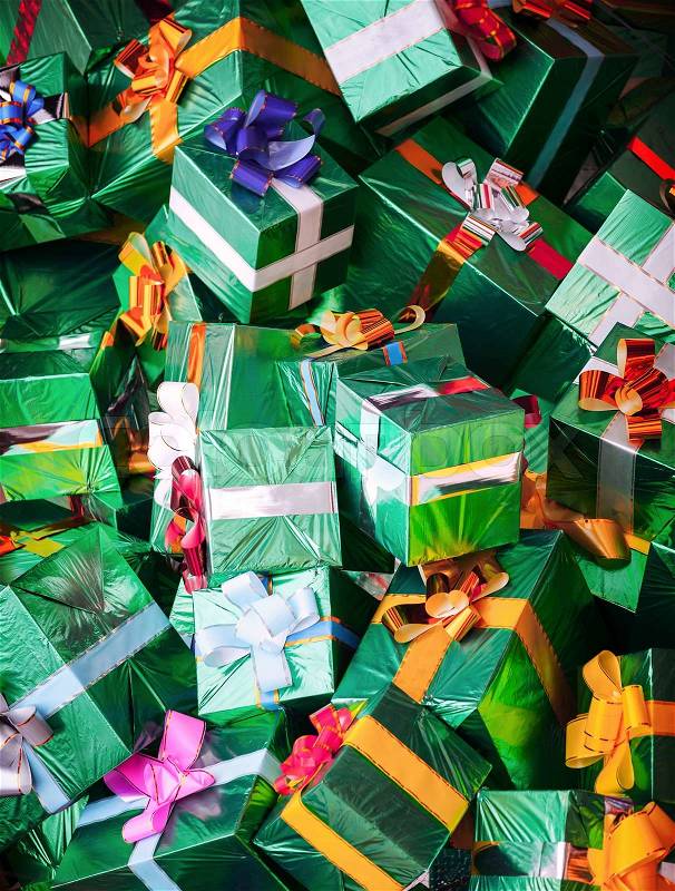 Photo background with huge pile of green shining gift boxes with colorful bows, stock photo