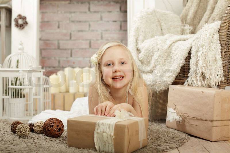 Smiling child girl with gift box at provence style home, stock photo