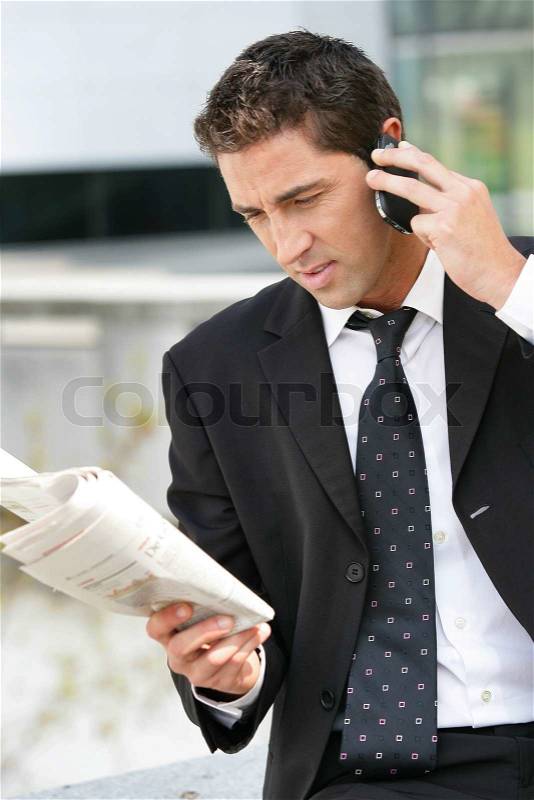 Businessman with phone and newspaper, stock photo