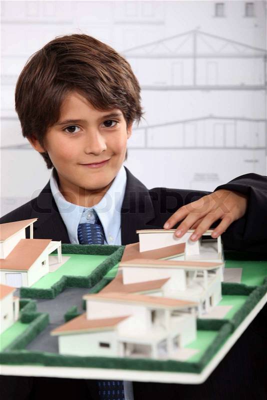 A little boy wearing suit and tie behind a district model, stock photo