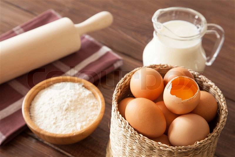 Eggs, milk and flour on a wooden table, stock photo