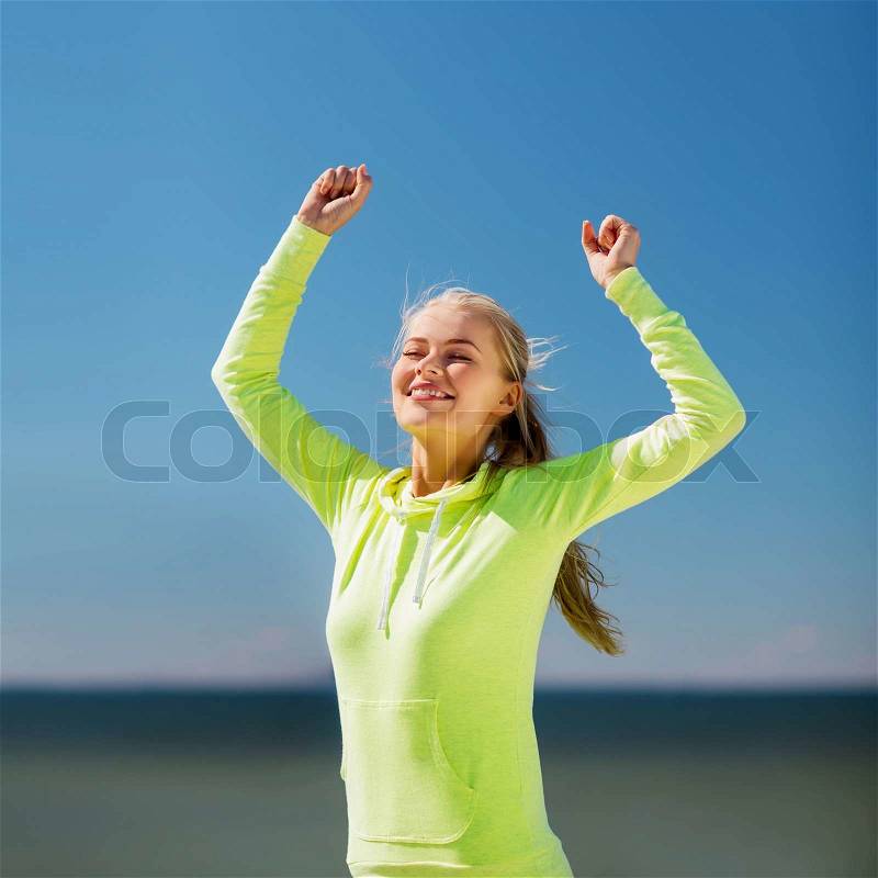 Sport and lifestyle concept - woman runner celebrating victory, stock photo