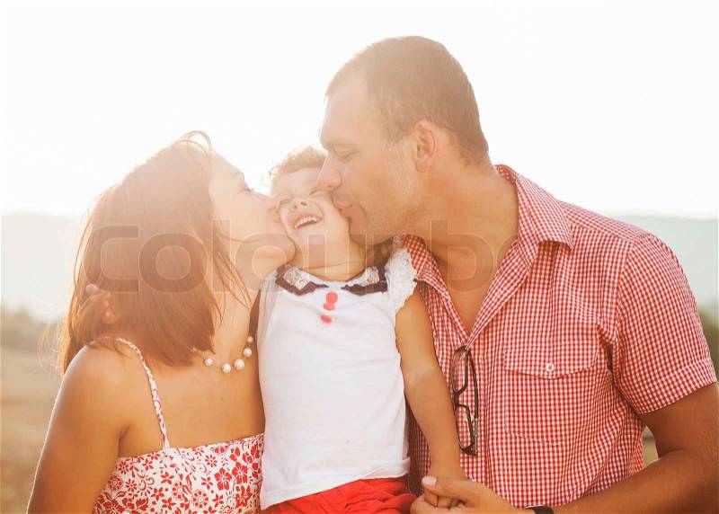 Happy mother, father and daughter in sunset, stock photo