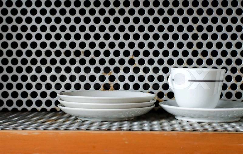 Clean plates and cups on grunge metal Grill Pattern Background, stock photo