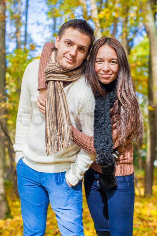 Portrait of Happy couple in love in autumn park on a sunny fall day, stock photo