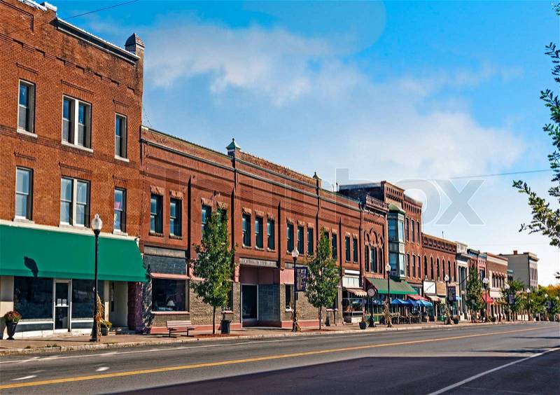 A photo of a typical small town main street in the United States of America. Features old brick buildings with specialty shops and restaurants. Decorated with autumn decor. , stock photo