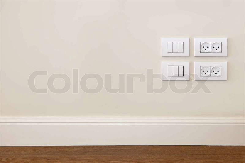 Empty wall with wooden floor. On the wall power outlet and light switch , stock photo